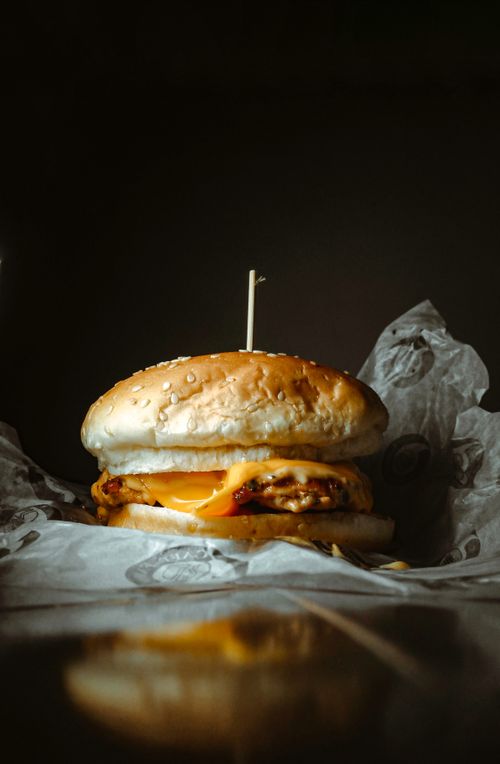 Free Delicious cheeseburger with melted cheese on a sesame seed bun, perfect for food photography. Stock Photo
