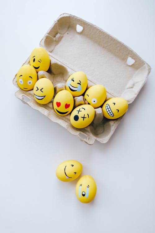 Eggs with Humorous Emoticons Painted on Them in an Egg Carton
