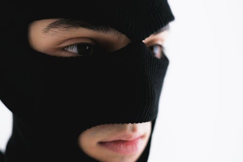 Close-Up Shot of a Person Wearing a Robber Mask