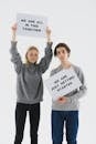 Man and Woman in Gray Sweater Holding Posters with Message