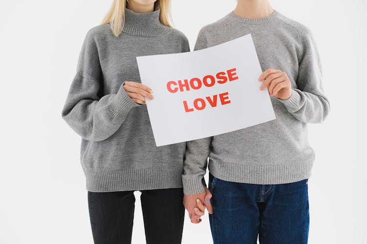 A Couple In Gray Sweater Holding White Paper With Choose Love Print