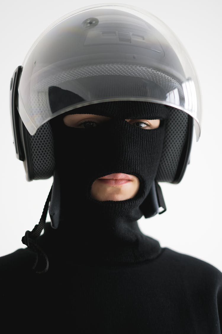 A Person Wearing A Helmet And A Black Full Face Mask