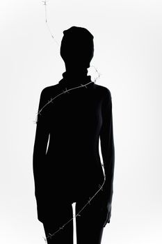 Artistic silhouette of a woman wrapped in coiled barbed wire on a white background.