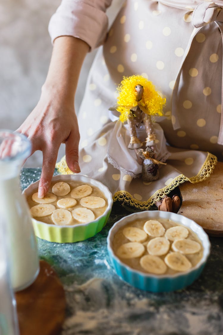 A Hand Putting The Sliced Banana On A Bowl With Oats