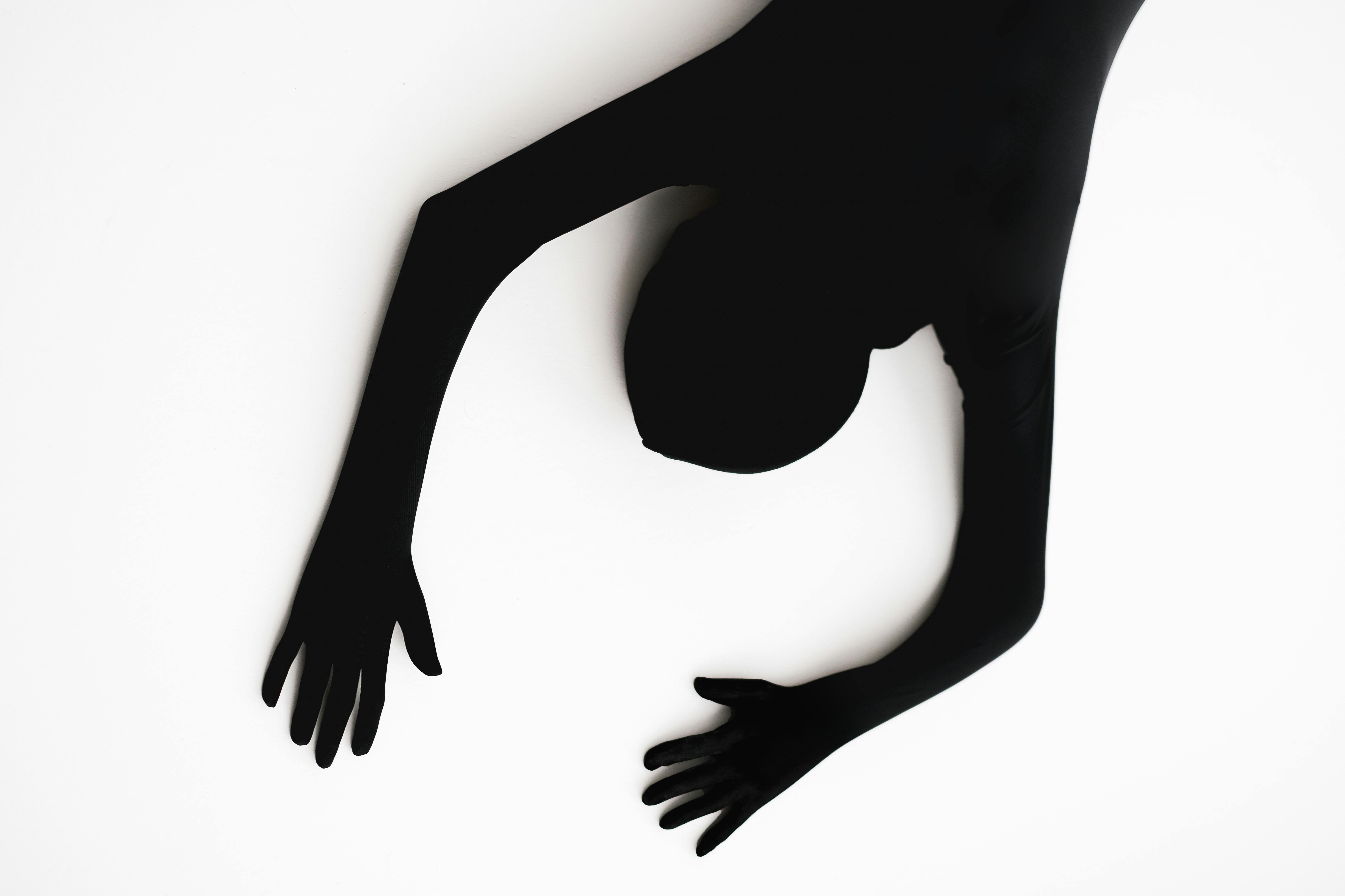 Person in Black Zentai Suit Lying Down on White Surface · Free