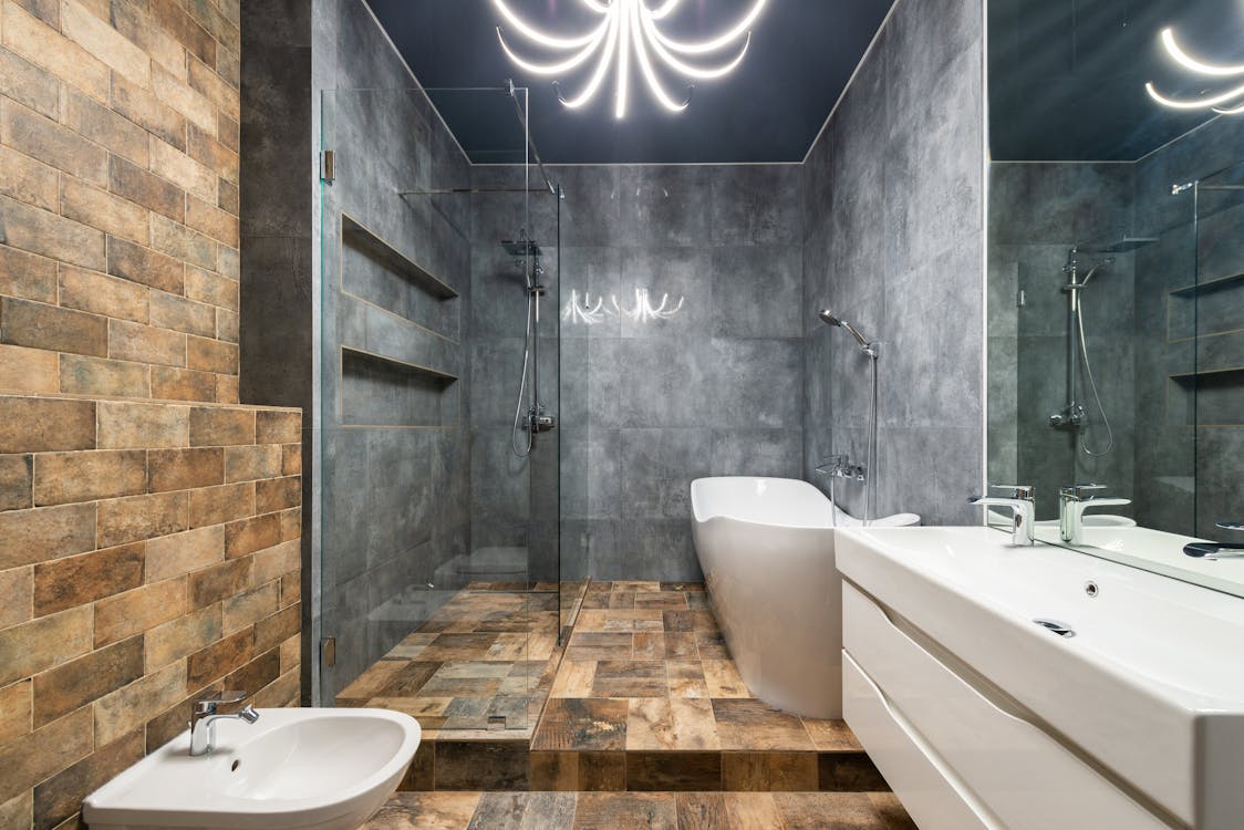 Bathroom interior with bidet near sink and bath with shower