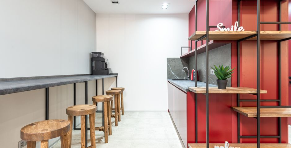A modern office pantry with a counter and stools — the number-one pest source in an office
