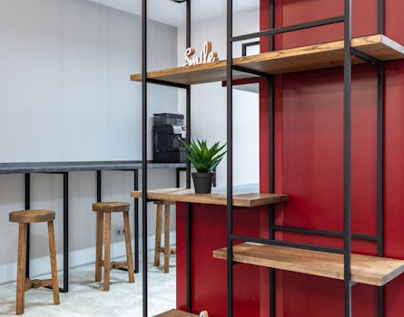 Interior of modern workplace with wooden shelves with potted plant and word smile next to counter and stools