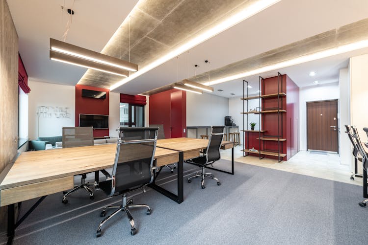 Office Interior With Table And Chairs Near Shelves