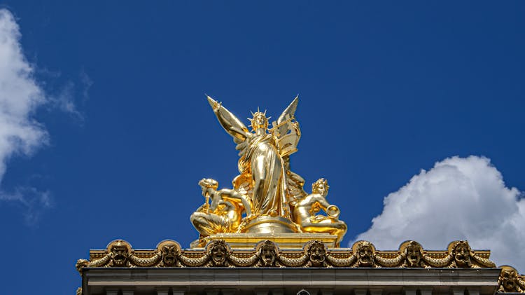 Gold Angel Statues Holding Musical Instruments On The Roof Of Palais Garnier