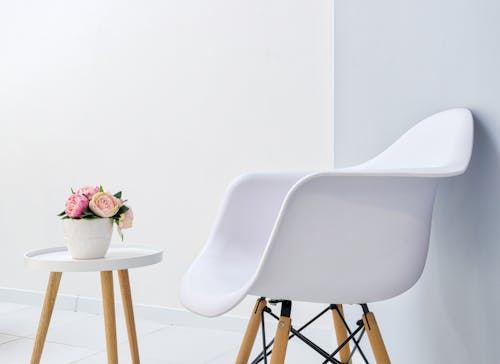 Modern armchair against blooming peonies on table in lobby