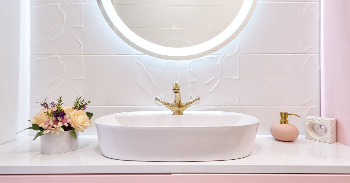 Interior of modern bathroom with luminous mirror hanging under sink with faucet near blooming flowers and soap