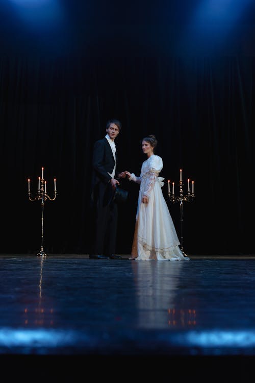 Man in Black Suit Standing Beside Woman in White Dress