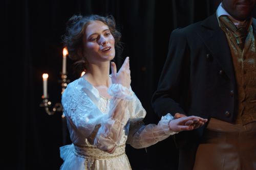 Free An actress in period costume performs a dramatic scene on stage with elegant gestures. Stock Photo