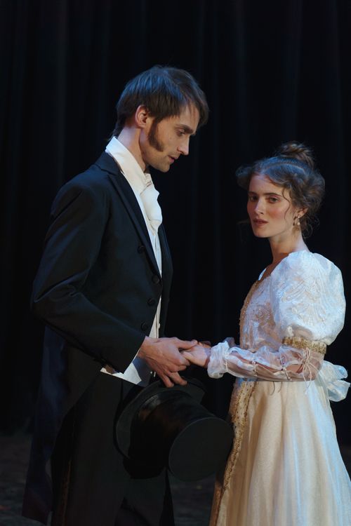 Free An elegant couple in vintage costumes performing a romantic theatrical scene on stage. Stock Photo