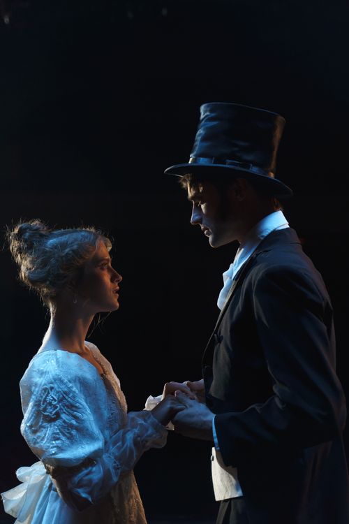 Free A dramatic theater scene depicting a couple in Victorian attire holding hands on stage. Stock Photo