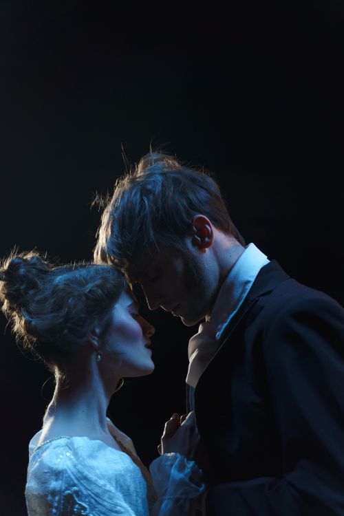 Free A dramatic and intimate portrait of a romantic couple embracing on stage under spotlight. Stock Photo