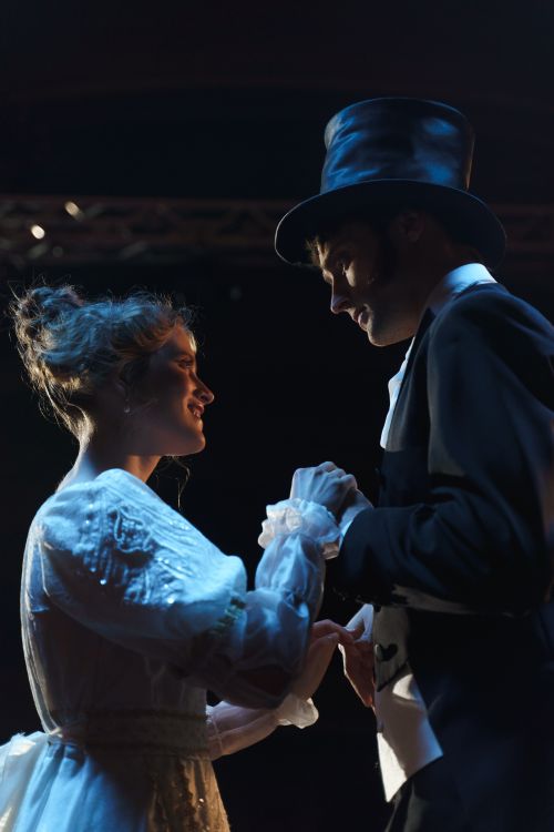 Free A romantic couple performs a dramatic scene on stage, dressed in elegant costumes. Stock Photo