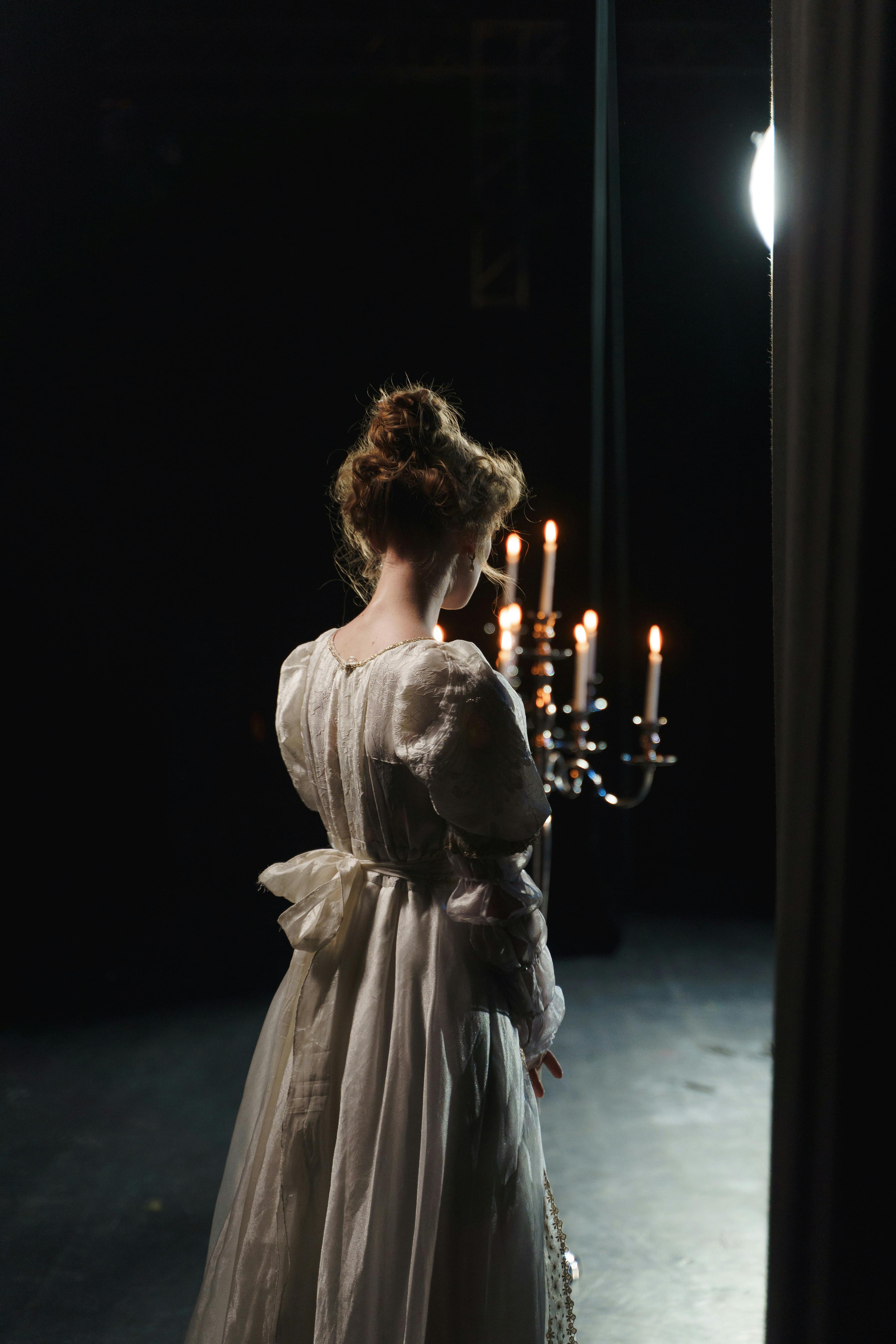 girl in white dress holding a candelabrum