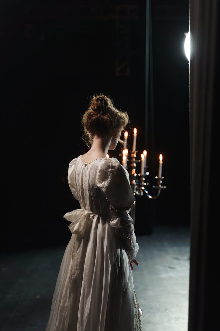 Girl In White Dress Holding A Candelabrum