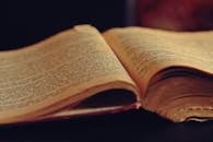 一本打开的老式书，书页泛黄老化，文字已经褪色