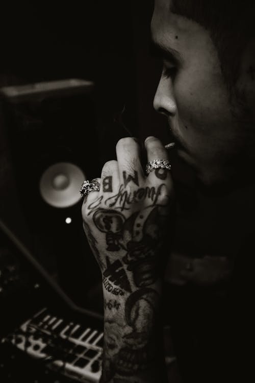 Black and White Photo of a Man with Tattoos on his Hand