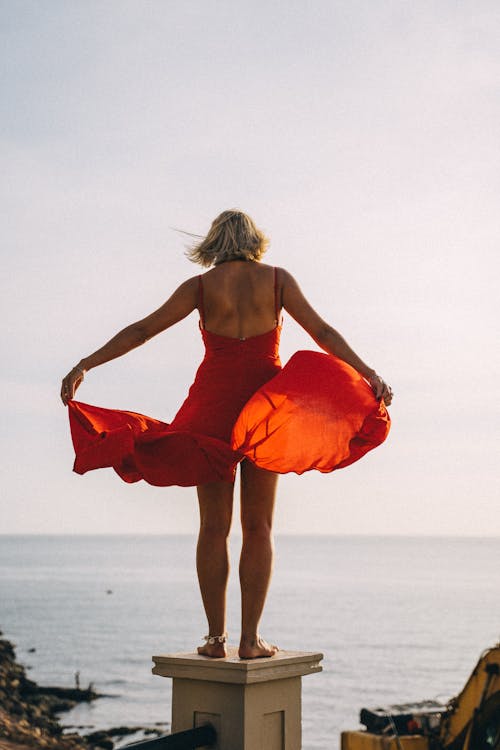 Free Back View of a Woman Touching Her Red Dress Stock Photo