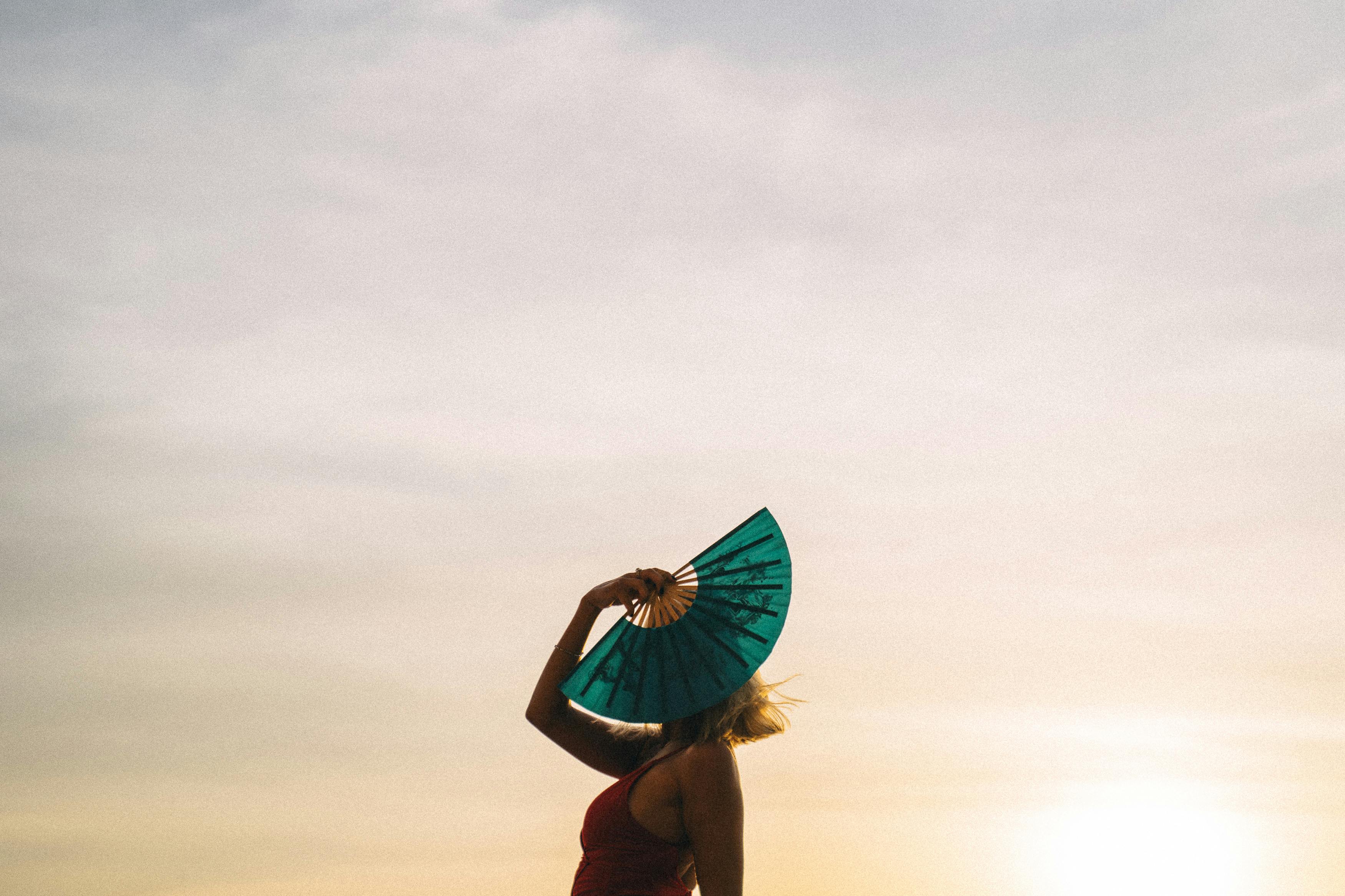 woman in red bikini holding blue umbrella