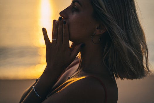 Silhouetted portrait of a woman by the sea during a vivid sunset. Perfect for artistic stock photos.