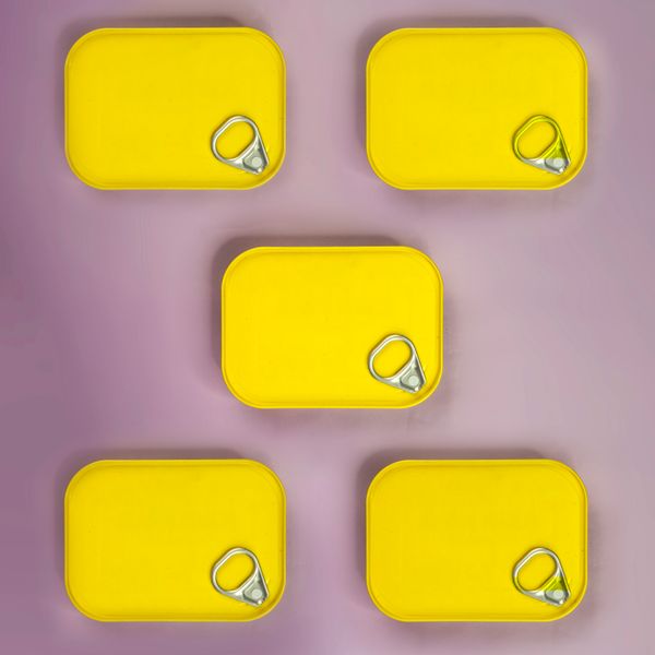 Yellow tins arranged on a lilac background — photo by Karen Laark Boshoff on Pexels