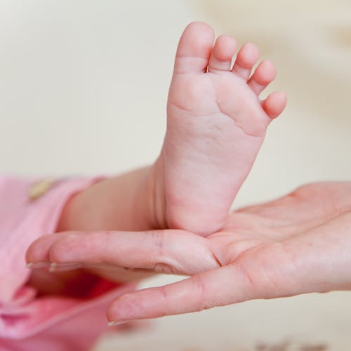 Free Babys Foot on Person's Hand Stock Photo