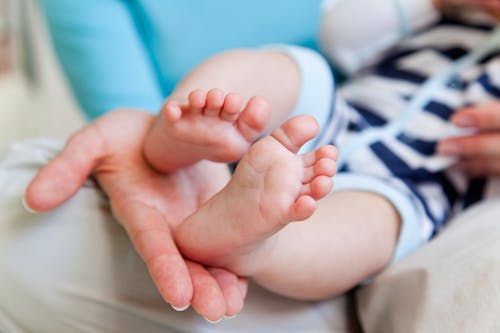 Baby's Feet on Person's Hand