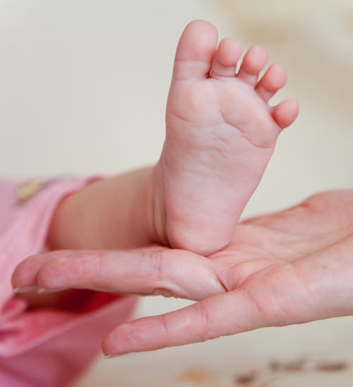 Free Photo of a Child's Foot on a Person's Hand Stock Photo