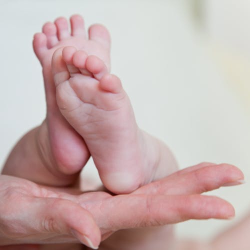 Photograph of an Infant's Feet on a Person's Hand
