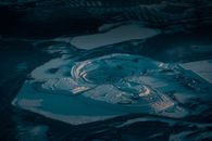 Drone view of large deep crater covered with snow and frozen lake in winter valley