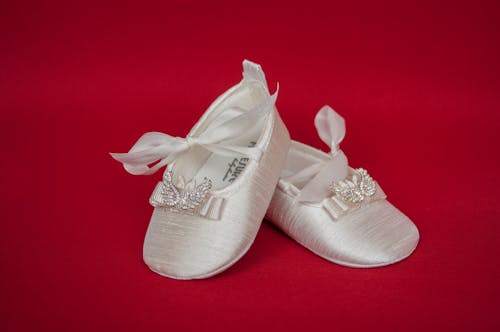 Close-Up Shot of White Sandals on a Red Surface