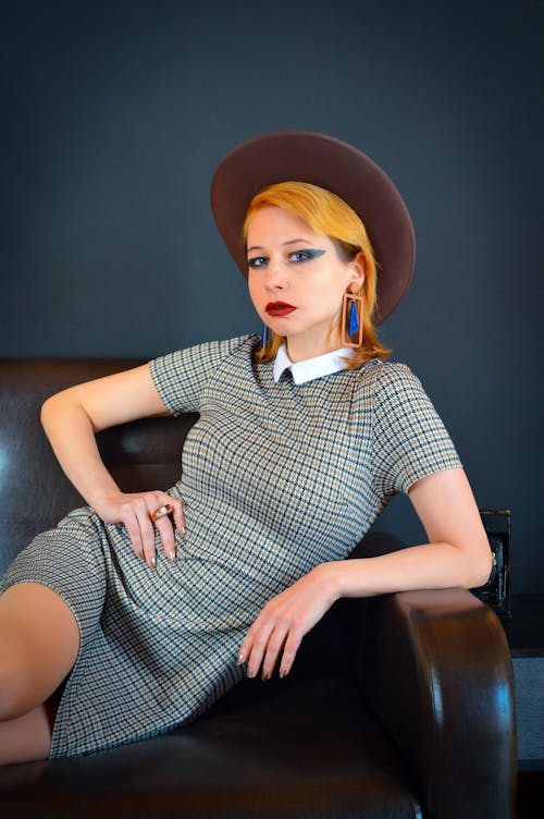 Stylish woman wearing checkered dress and hat