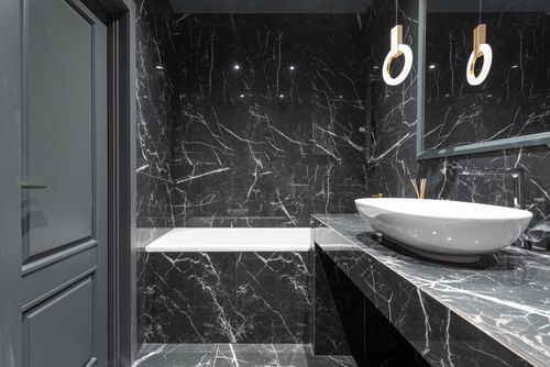 Free Stylish bathroom with bathtub and round lamp hanging above sink placed on marble surface Stock Photo
