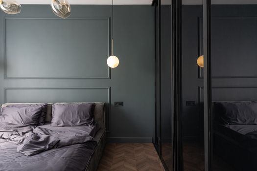 Stylish bedroom with unmade bed near cupboard