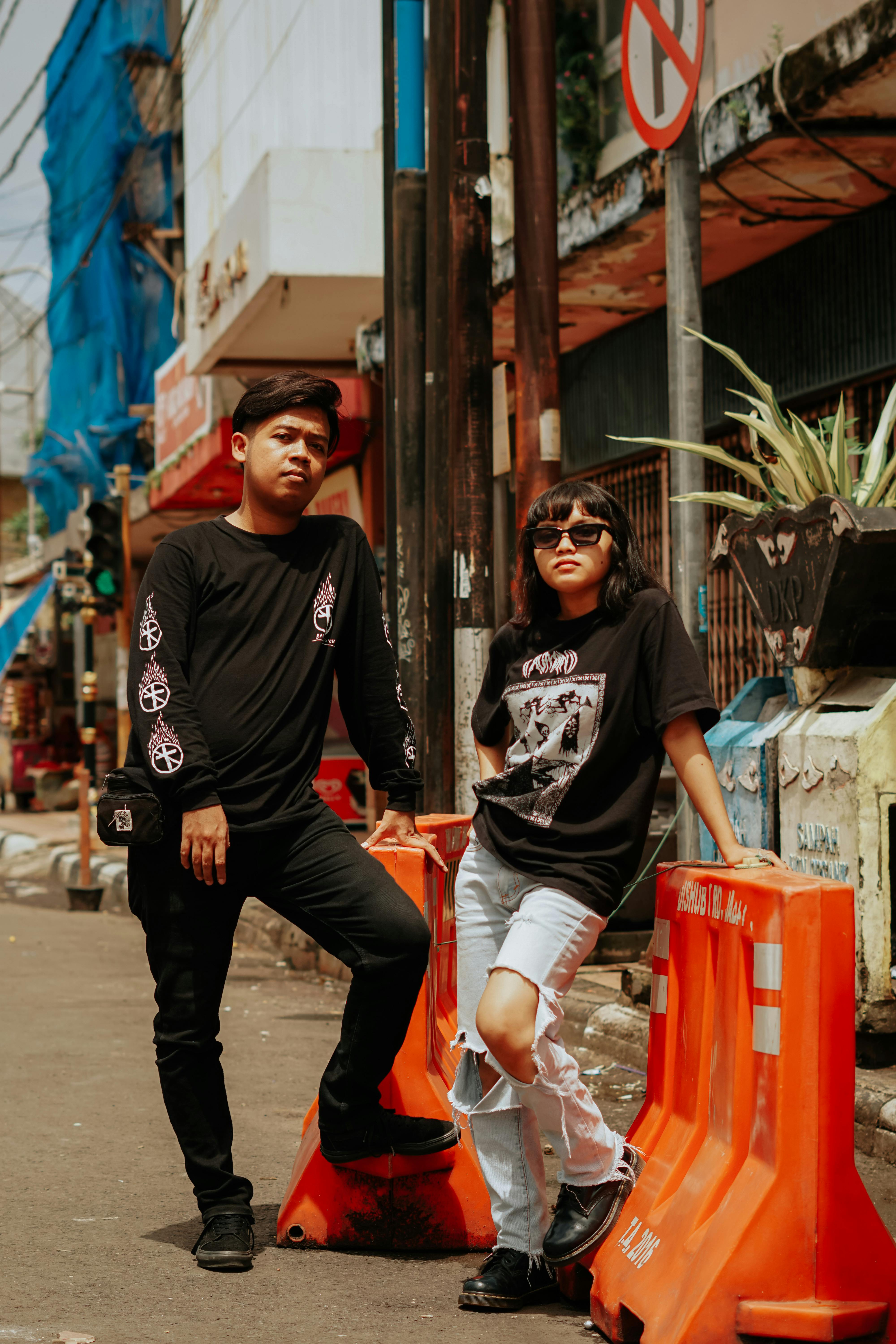 Man And Woman Standing Beside The Orange Road Barriers · Free.