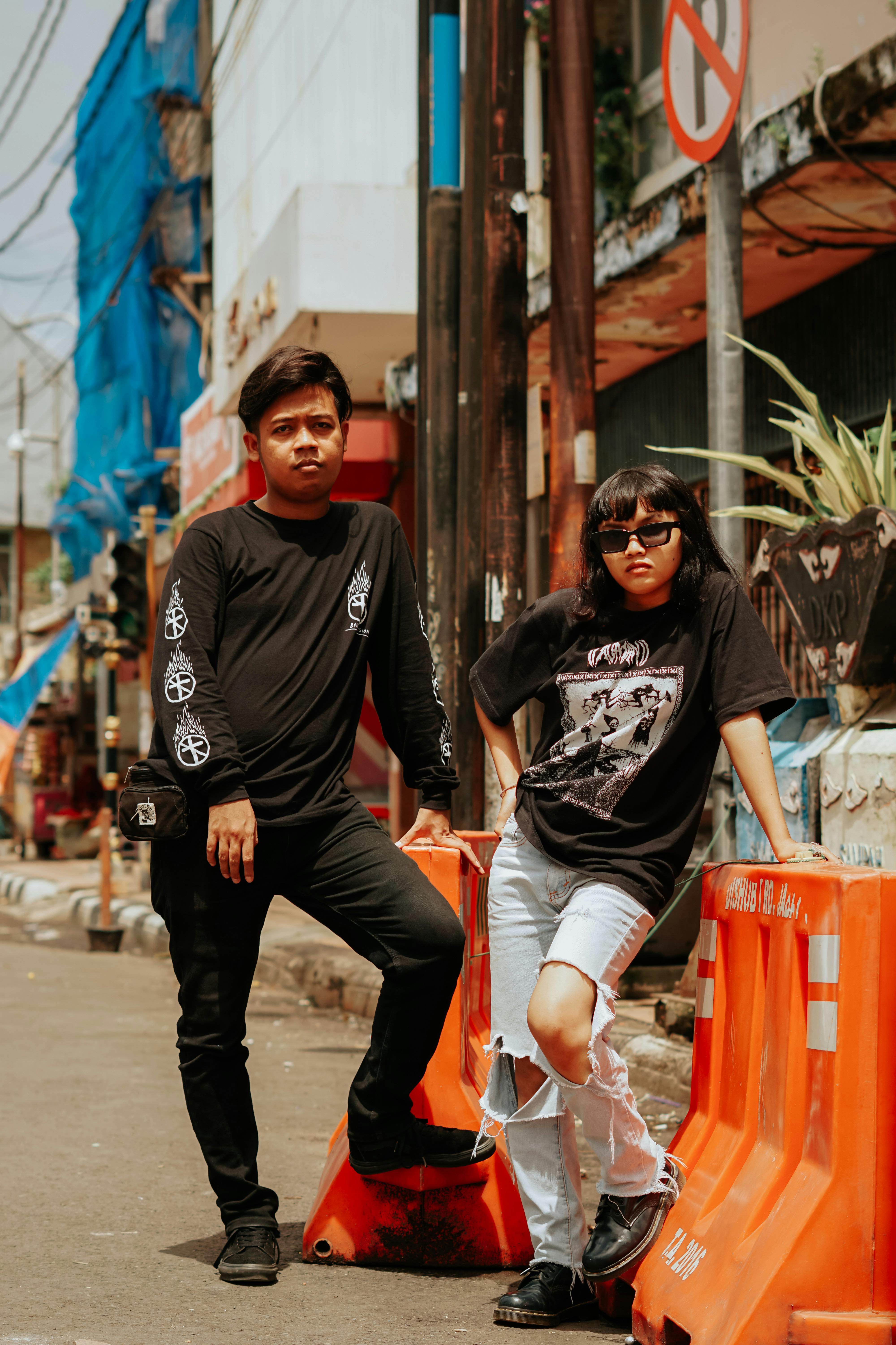 Man And Woman Standing Beside The Orange Road Barriers · Free.