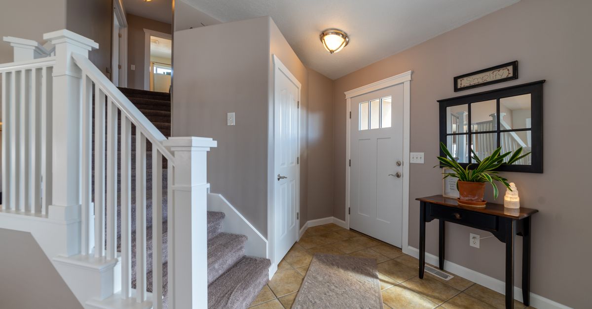 Bright entryway featuring stairs, a door, and stylish interior design elements.
