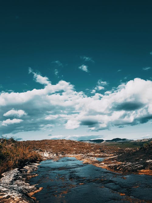 A Body of Water Under the Blue Sky and White Clouds