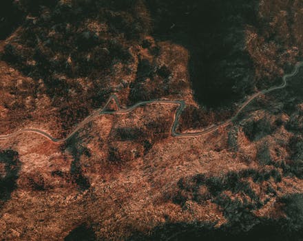 Stunning aerial view of a winding road cutting through rugged mountains in Fundina, Montenegro.