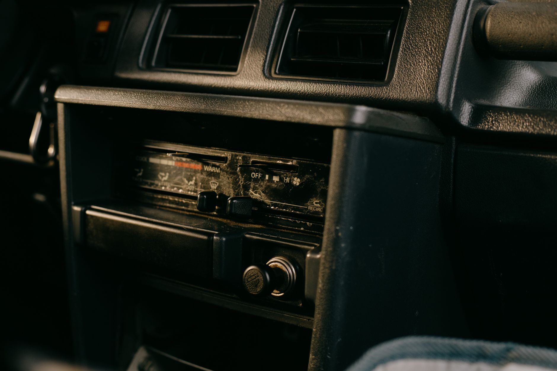 Close-up of an old car's dashboard featuring a vintage radio setup.
