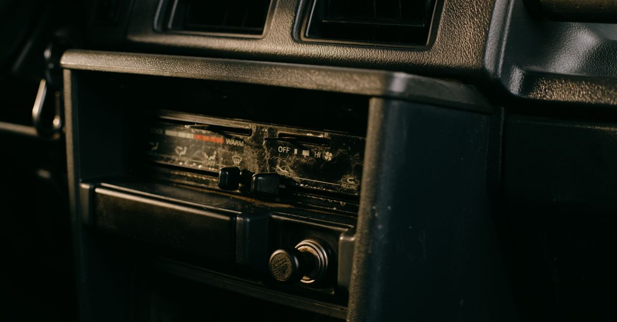 Close-up of an old car's dashboard featuring a vintage radio setup.