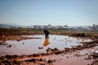 Poor man washing legs in dirty water of village