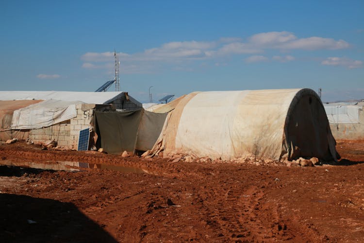 Shabby Tents And Brick Construction On Ground