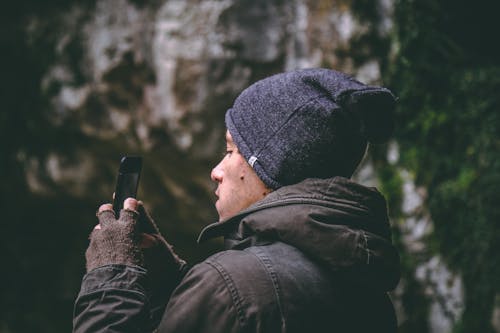 Człowiek W Czapce Trzymając Smartfon