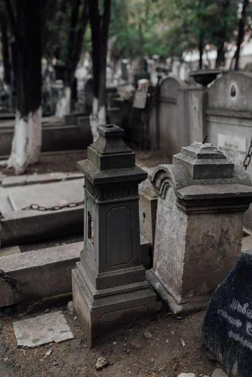 Free Ancient gravestones in a serene cemetery with atmospheric lighting and moss-covered stone. Stock Photo
